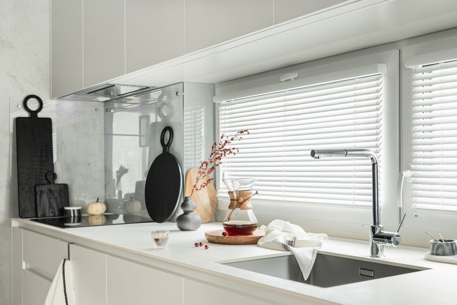 White blinds on the kitchen windows.