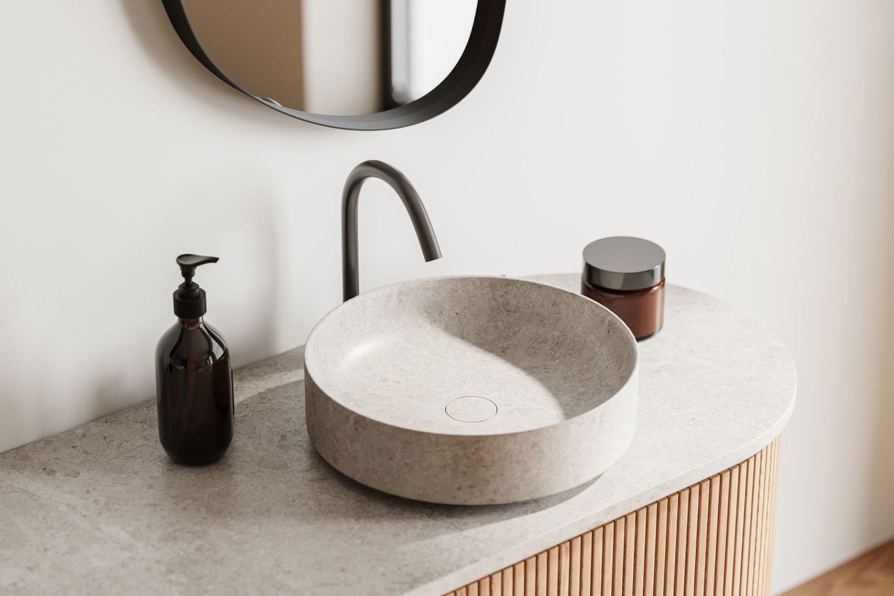 Natural stone countertop and sink over bamboo vanity.