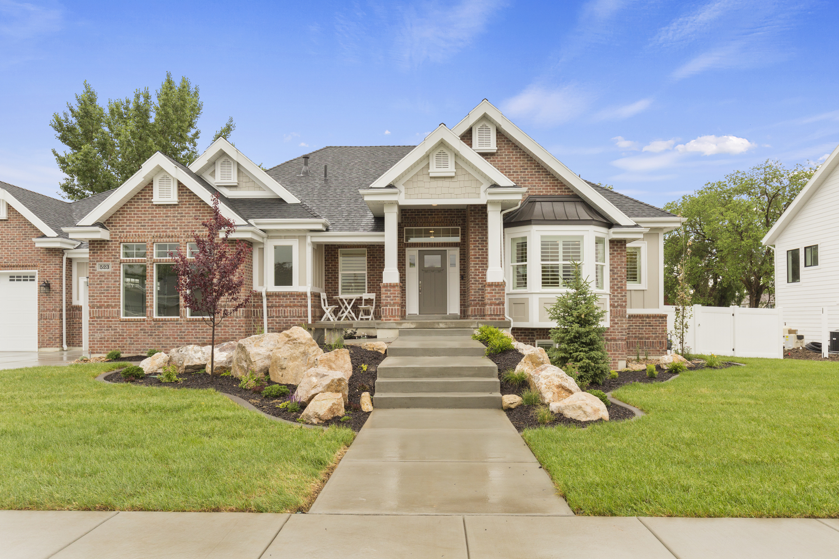 Exterior of a home with brick siding and window trims that match the gable roof