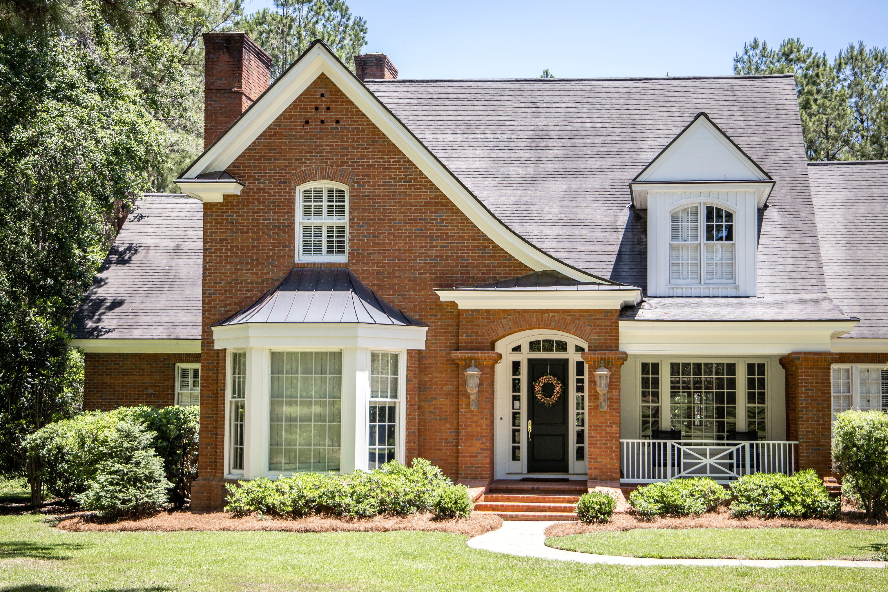 Exterior of a home with brick siding layered window trims
