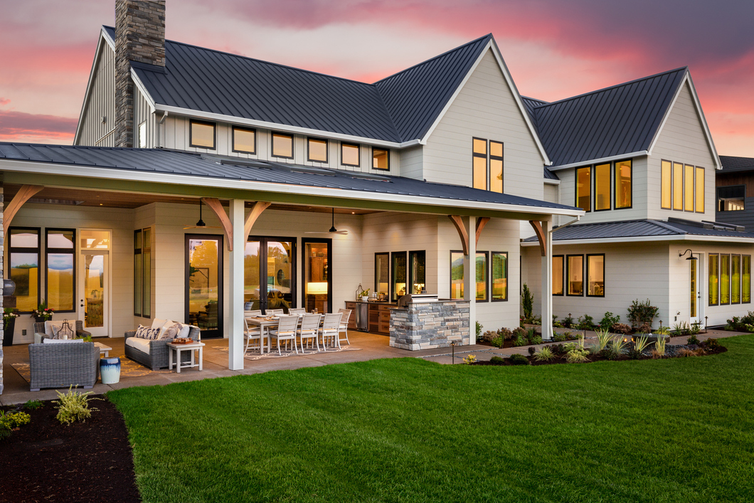 Exterior of a home with light colored siding and black window trims
